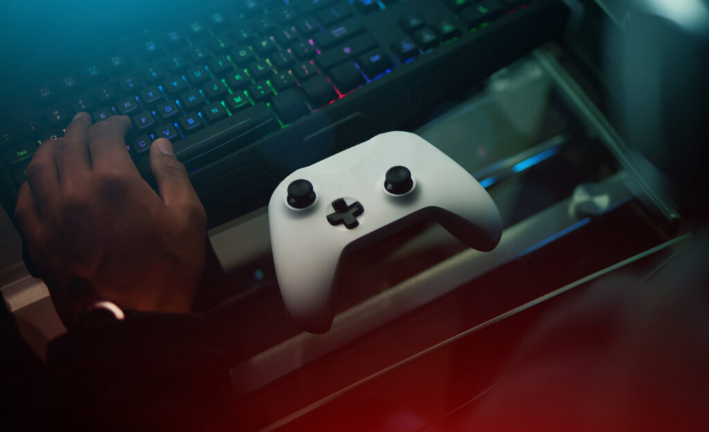 hand-video-game-controller-keyboard-desk-gamer-setup-online-streaming-with-competition-esports-gaming-technology-streamer-person-dark-room-playing-tournament-with-joystick